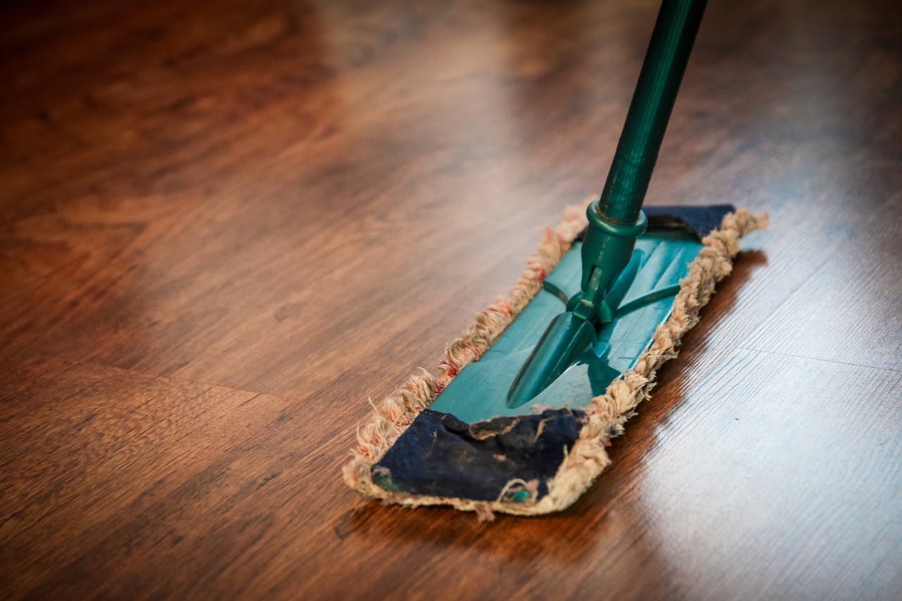 A propos A detailed view of a mop cleaning a wooden floor, showing texture and pattern.